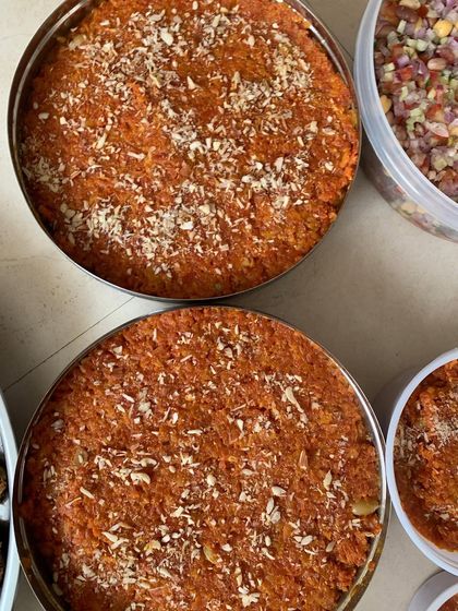 Large bowls of my homemade Gajar ka Halwa, a classic winter dessert, prepared for a large party order.