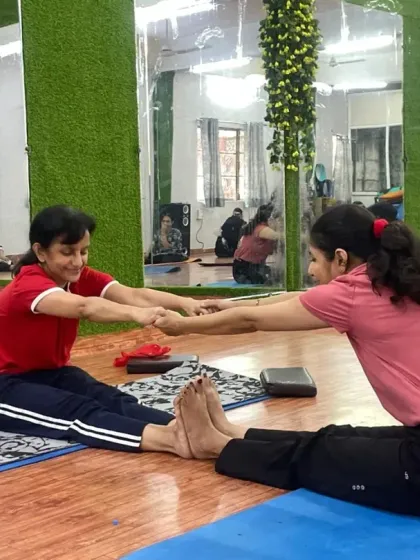 With a partner's help, you can often go deeper into a stretch. These students are supporting each other to improve their forward fold and connect through the practice.
