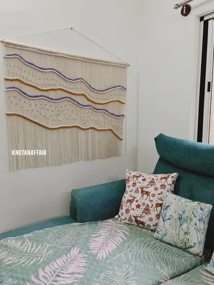 Here is a large 4-foot by 3.5-foot macraweave wall hanging I created, seen here in its new home. The client wanted specific shades of purple and mustard woven in, and I love how the colors pop against the natural cotton. This is a great way to add texture and a personal touch to your living room.