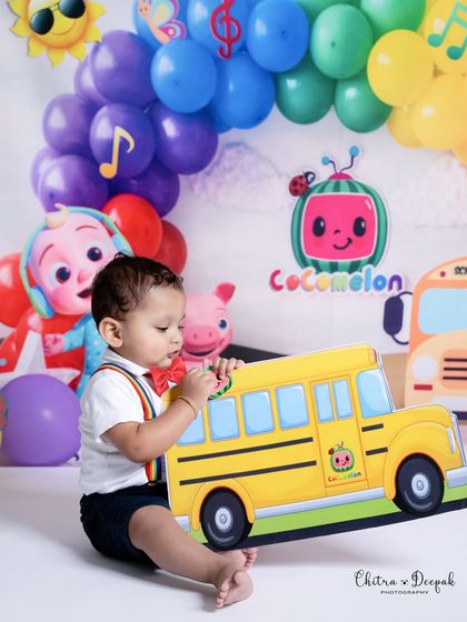 A playful shot from the Cocomelon session, with the baby interacting with a bright yellow school bus prop, adding a fun narrative element.