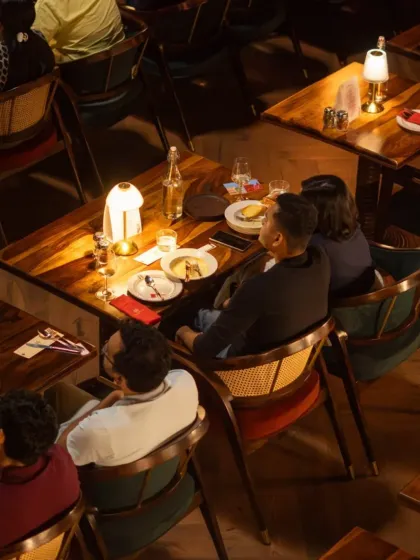 An overhead view of our setup, showing the intimate table arrangements. We design our seating to be perfect for couples and small groups, allowing for conversation and a shared experience while maintaining a clear view of the screen.