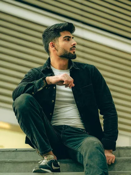 A full-body shot of a model sitting on stairs, capturing an urban, relaxed pose. This is a great example of using the environment to create a compelling composition.