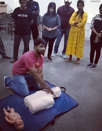 A participant practices the correct hand placement for chest compressions during the CPR module.
