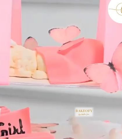 A detailed shot of the baby girl swing cake, showing the delicate fondant work and butterfly accents on the swing.