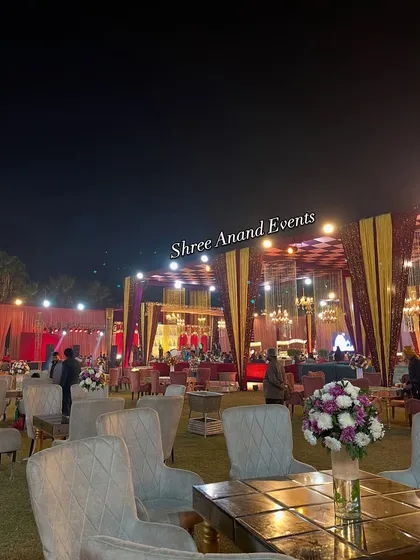 A nighttime view of the event space, with comfortable seating arrangements and the main stage visible in the background.