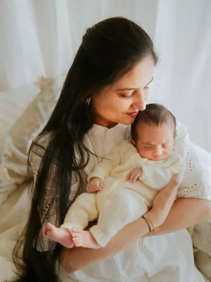 A mother's gentle embrace. She holds her new baby with so much love and tenderness in this lifestyle newborn photo.