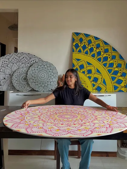 Me in my happy place, surrounded by my creations. Each piece, whether it's black and white, pink, or yellow, tells a different story. I love creating custom mandala art that brings life to a space.