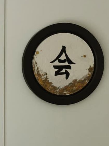 A close-up of one of the Japanese calligraphy panels. The contrast between the bold, black character and the delicate, textured gold leaf is just beautiful.