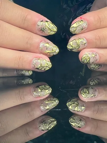 A full view of the unique 3D sculpted gold nail art.