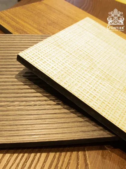 A close-up of two veneer samples. One has a fine, cross-hatch texture, while the other features clean, vertical flutes. Both are on a sturdy plywood base.