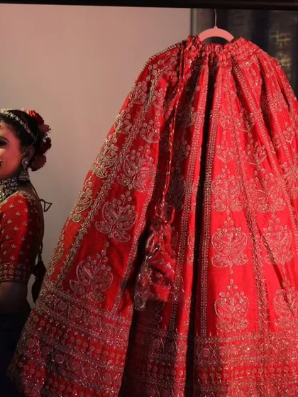 A smiling bride, ready to wear her lehenga. The joy and excitement are palpable.