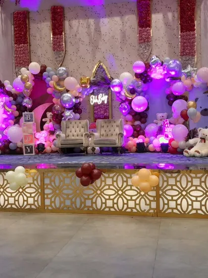 A beautiful stage setup for a baby shower with an 'Oh Baby' theme. The decor features a soft color palette, teddy bear cutouts, and two elegant chairs for the parents-to-be.