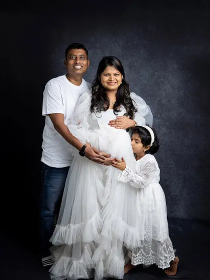 Including older siblings in a maternity shoot is a wonderful way to capture the family's excitement. Here, a big sister-to-be gives her mom's baby bump a sweet kiss.