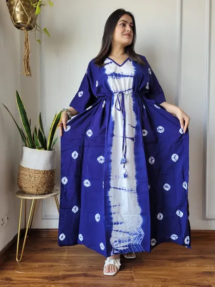 This indigo and white kaftan features a unique tie-dye pattern with dotted motifs. The drawstring waist is adorned with tassels for an extra touch of detail.