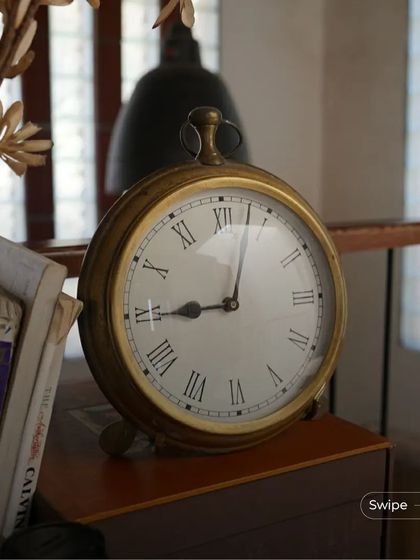 A vintage-style brass clock adds a touch of timeless elegance to a study nook. It's these small, carefully chosen details that complete the story of a home.