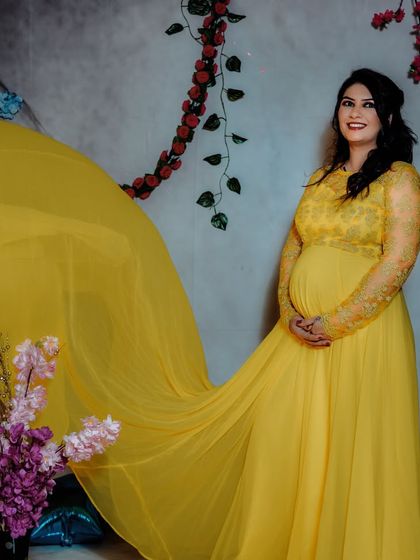 A classic solo studio portrait in a vibrant yellow gown. The flowing fabric adds a sense of movement and grace, creating a cheerful and elegant image.
