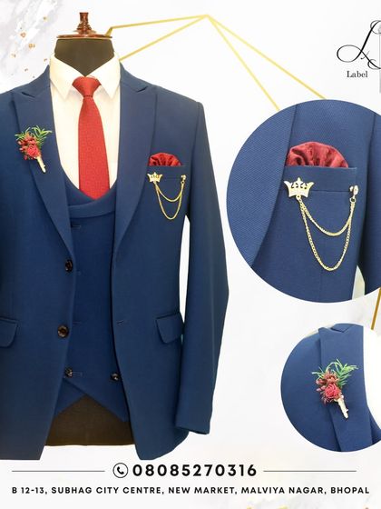 Where fashion meets majesty. This blue three-piece suit, accessorized with a red tie and custom lapel pins, shows how details can elevate a classic look.