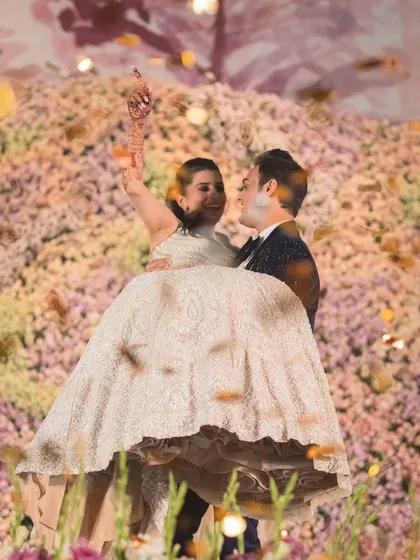 A joyful lift during a couple's performance in front of a floral stage. We incorporate fun and impressive moves that are safe and easy to learn.