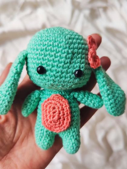 Another view of the mint green amigurumi bunny. Its long, floppy ears and tiny details make it an irresistible little friend.
