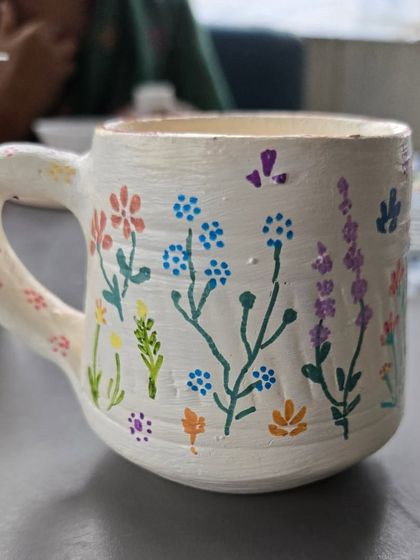 A beautifully hand-painted mug adorned with delicate wildflowers. This is a perfect example of the lovely, functional art you can create and take home.