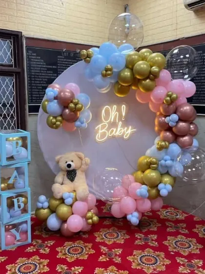 Celebrate a new arrival with a dedicated baby shower setup. This "Oh! Baby" theme uses a circular backdrop with a neon sign, a mix of pink, blue, and gold balloons, and adorable details like a teddy bear and transparent "BABY" blocks.