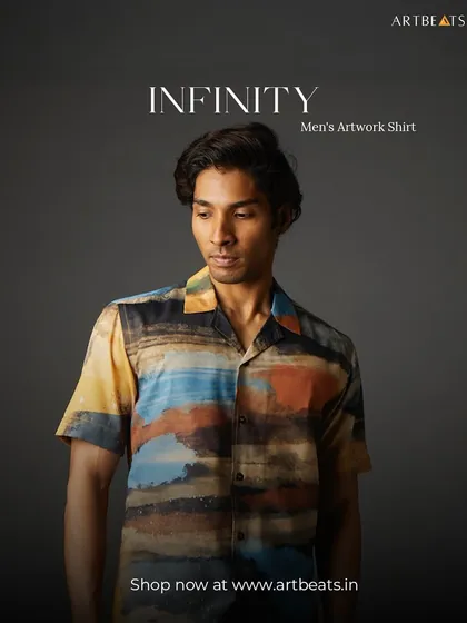 The Infinity men's artwork shirt. The design is an abstract landscape of layered colors, from earthy yellows and oranges to deep blues, creating a sense of boundless horizons.
