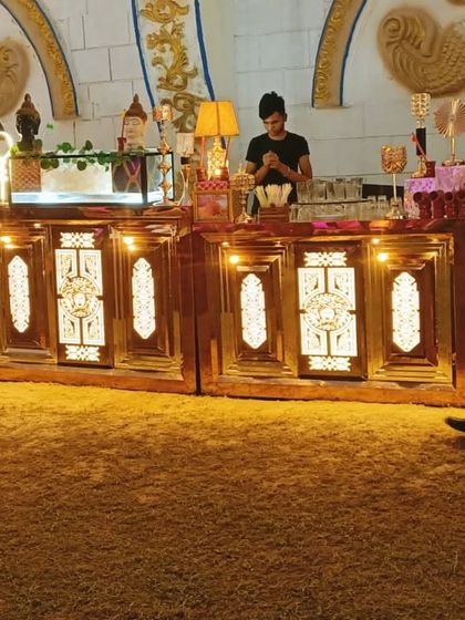 An ornate, lit-up counter setup for serving drinks or desserts. This kind of presentation adds a lot of charm to any wedding or party.