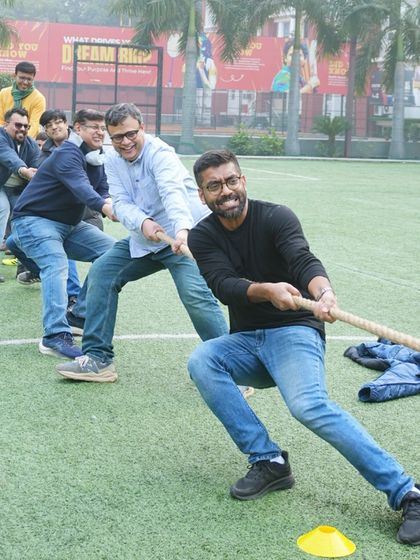 The fun isn't just for kids. Dads join in for a spirited game of tug-of-war during a football-themed party, showing that everyone can be a part of the action.