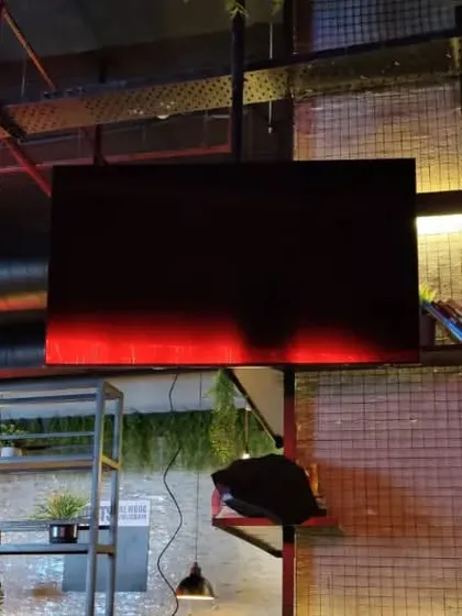 The same display at BrewDog before being powered on. We focus on clean cable management and sturdy mounting, even in complex industrial-style interiors with exposed pipes and metalwork.