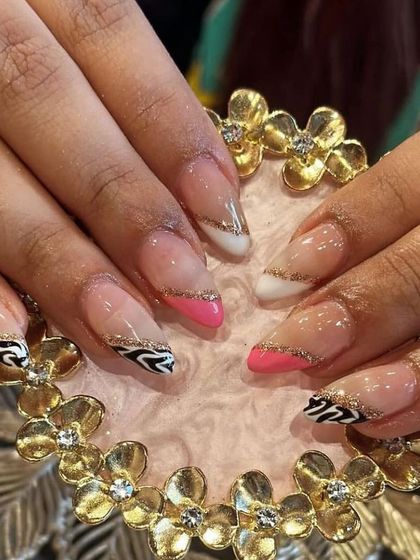 A trendy and bold nail art design combining zebra print, hot pink, and gold glitter lines.