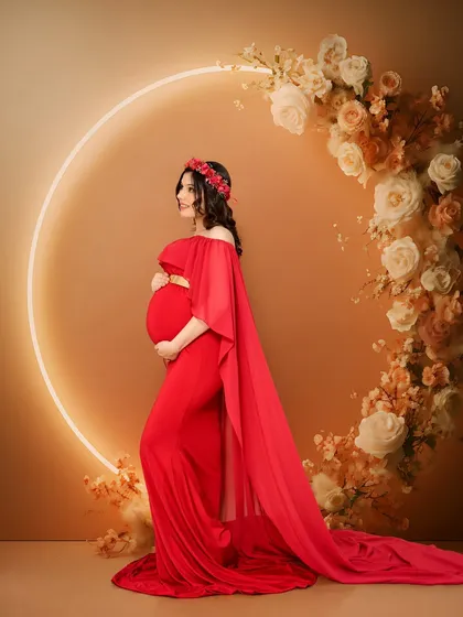 A powerful solo maternity portrait of a mother-to-be in a striking red gown from our client closet. The glowing halo light and floral ring create a modern, goddess-like feel, celebrating the strength and beauty of pregnancy.