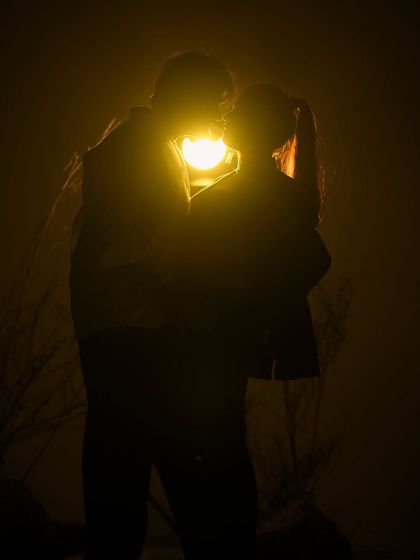 A silhouette of love. This artistic shot uses a single light source to create a dramatic and intimate silhouette of the couple embracing, highlighting their connection in a unique way.