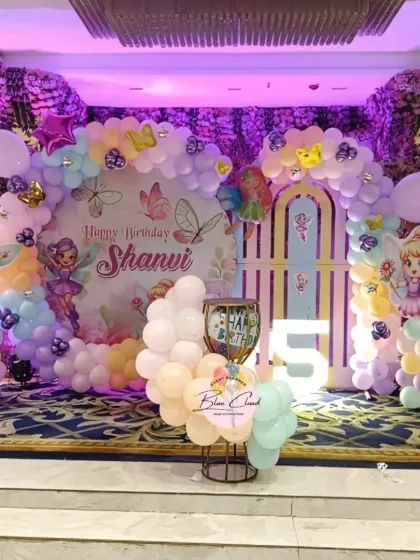 A full stage view of a magical fairy-themed 5th birthday, with intricate balloon work and character props.