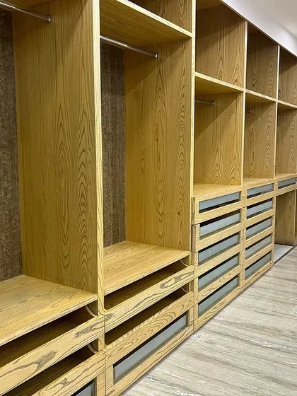 This expansive 45-foot walk-in closet is a testament to our expertise in creating bespoke storage solutions. We designed this custom wardrobe with a natural wood veneer finish, incorporating a mix of open shelving, hanging space, and sleek drawers to ensure every item has its place. It’s a perfect blend of grand scale and practical organization.