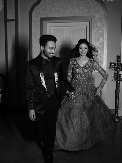 A classic black and white shot of the couple walking hand-in-hand, capturing a timeless and elegant feel.