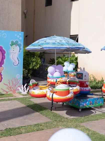 A fun merry-go-round ride with a seahorse theme, providing entertainment for the little guests at an outdoor ocean party.