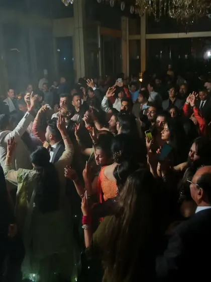 Another perspective of the high-energy reception dance floor. The dramatic lighting and the crowd's excitement make for a dynamic and memorable photograph.