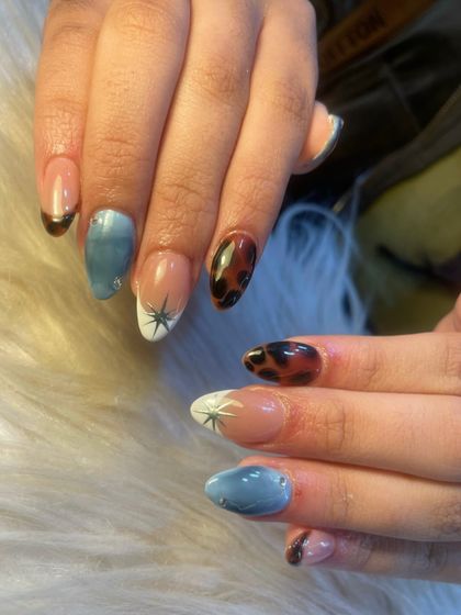 A cool and eclectic summer set. We combined a blue marble effect with a tortoiseshell pattern and hand-painted starbursts for a unique and artistic manicure.