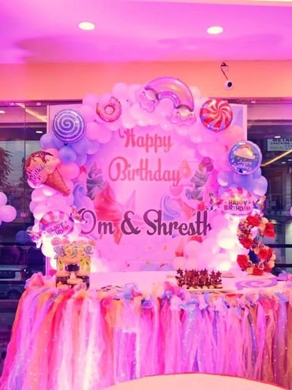This Candyland themed cake table is decorated with a rainbow tulle skirt. The backdrop features lollipop and candy foil balloons, creating a super sweet setting for the celebration.