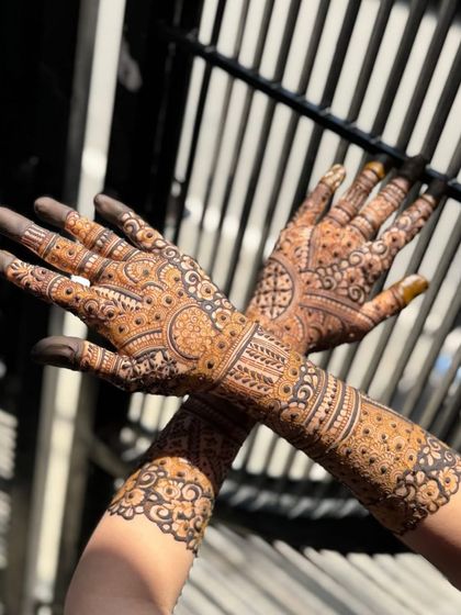A close-up of the palms in the sunlight, showing the rich color of the organic henna.