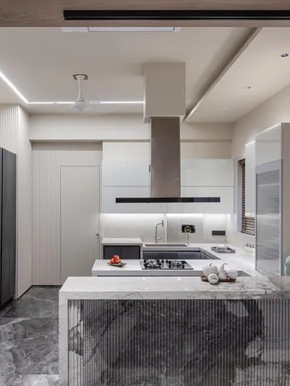 My expertise goes beyond wardrobes. Here is an open-concept kitchen that seamlessly connects to the living area. I used a mix of dark ceramic-finish cabinets and a fluted stone island to create a functional and social heart of the home.