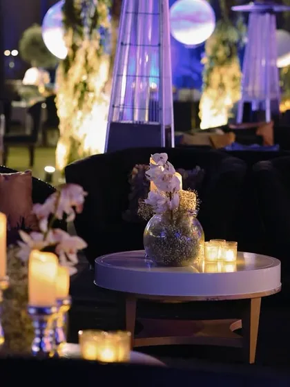 Another view of the candlelit lounge, with tall candelabras and soft floral arrangements creating a sophisticated and intimate atmosphere.