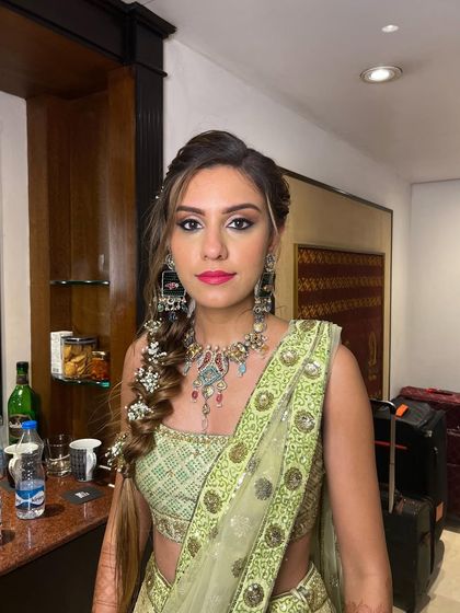 The complete Mehendi look, with the floral fishtail braid adding the perfect finishing touch to her green lehenga.