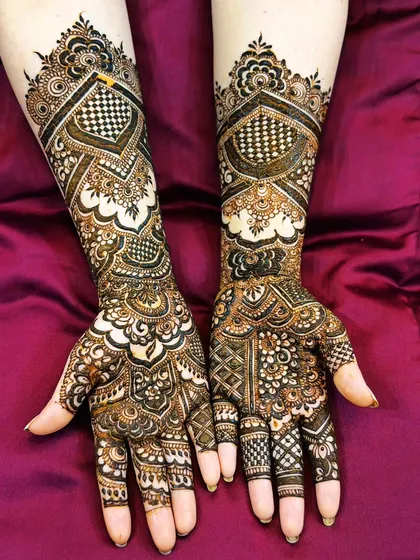 I love the precision of Pakistani mehendi. This design features fine lines, intricate checkerboard patterns, and bold shapes for a stunningly detailed look that extends up the arm.