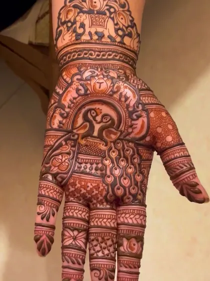 A lovely palm design featuring two peacocks forming a heart shape.