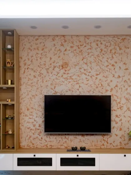 This TV unit is designed to be a feature, not just a utility. The large scale, textured wallpaper background, and clean lines of the console help it blend beautifully with the living room decor while providing ample storage.