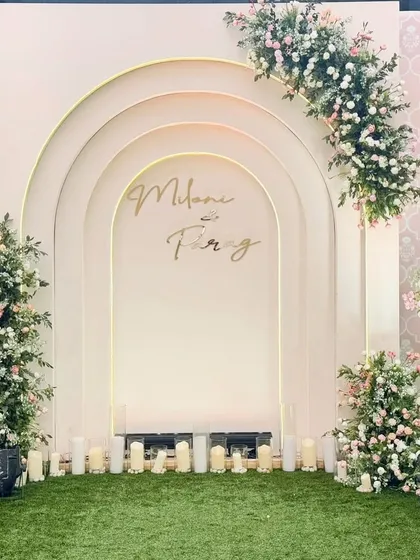 This personalized photo booth features layered arches and delicate floral arrangements in pastel tones. The couple's names in a custom script add a personal touch to this elegant backdrop.