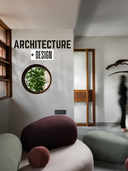 Our studio, recognized by Architecture+Design magazine. This view shows our reception area, where sculptural, pebble-like seating and a circular window framing the greenery outside embody our design philosophy.