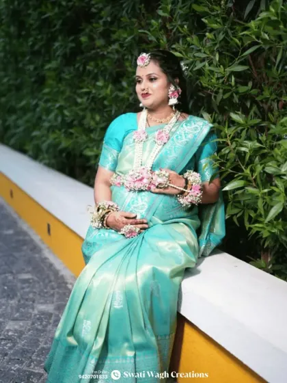 A serene moment captured. The floral kamarband and hathphool add a delicate touch to her beautiful light blue saree.