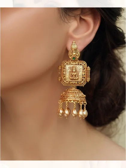 A pair of traditional temple jhumkas, featuring a square top with a deity motif and a classic dome with pearl drops.